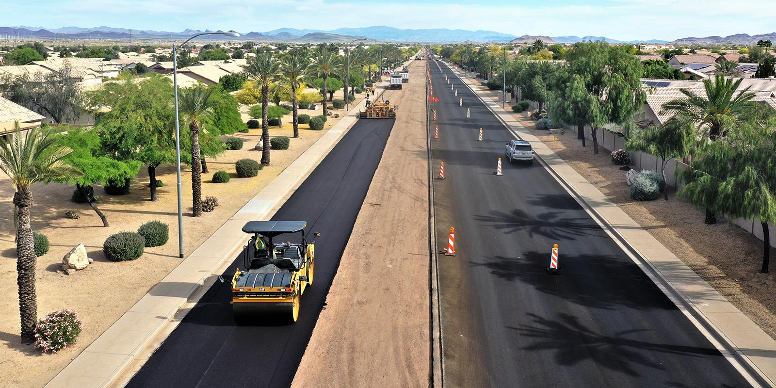 Roller compacting fresh asphalt during a residential street paving project in Arizona