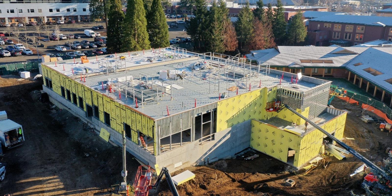 Aerial view of a steel-framed building under construction with exterior sheathing in place